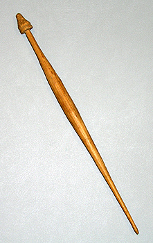 A long, thin, whittled bamboo spindle against a white background.